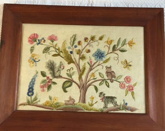 Ricamo antico raffigurante un albero con frutti, semi, fiori, uno scoiattolo, un gufo, un uccellino azzurro e farfalle, un coniglio e un agnello. Ricamato su tela di lino.