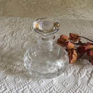 Vintage Clear Crystal Perfume Bottle with Glass Stopper. Round Bottle With Sunburst Bottom and Side Pointed Groves. Shiny Smooth Stopper.
