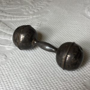Antique Sterling Silver Baby Rattle. Marked Sterling N12, w/ Markings Embossed Eagle and Lion with R inside a Shield. Barbell Shaped Rattle/