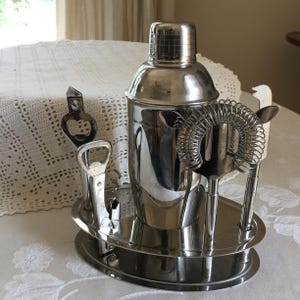 Vintage Bar Set in Stainless Steel. Can Openers, Corkscrew, Cutter and Mixer Plus Drink Shaker. All Accessories in Bar Display.