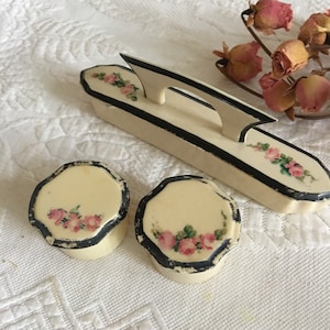 Vintage Bügel-Puffer- und Frisiertiergläser. Dubarry Pyralin Dresser Containers One mit einem Glas Liner und Kid Leather Nail Buffer. Handmalerei.