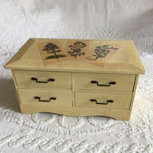 Vintage 4 Drawer Cabinet for Crafts or Jewelry. Herbs and Flowers Decorate the Top, Shaped Bottom. Creamy Yellow Shabby Chic Finish.