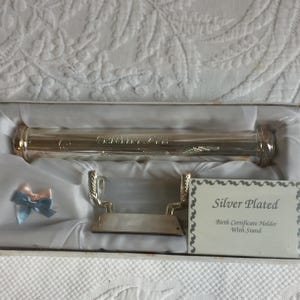 Vintage babyverzilverde geboorteaktehouder en standaard. Verpakt en verzegeld, ideaal als babycadeau.