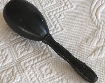 Huevo de zurcir antiguo de color negro con asa. Para zurcir calcetines o para coser. Exhibición de herramientas antiguas. Huevo de zurcir muy usado.