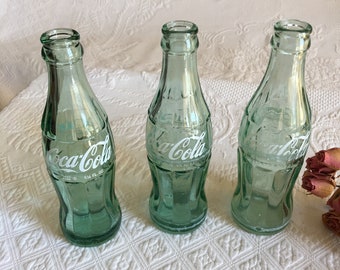 bouteille vide unique de Coca Cola de cru, verre vert. Choisissez : Kinston NC, No Marking ou Cursive des années 1960 des deux côtés et des détails moulés.