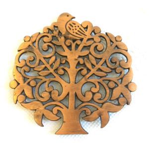 May include: A copper-coloured wooden tree of life design with a bird perched on a branch. The tree has intricate details and a cutout design.