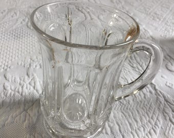 Vintage Heisey Teebecher mit seitlichem Henkel und Sonnenmotiv am Boden.
