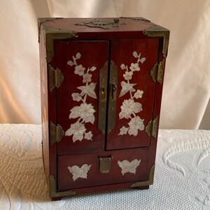 Vintage Oriental Style Mother of Pearl Inlay Flowers and Brass Hinges and Drawer Pulls. 2 Doors and 4 Drawers. Red Silk Lining. Ring Holder.
