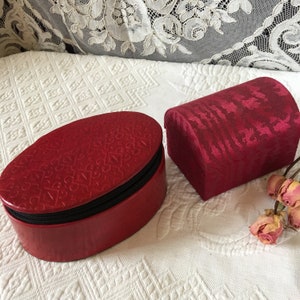 Pair of Red Jewelry Cases. Moire Fabric Covered Domed Box With Tassel and Embossed Sheep Leather Box With Shelf and Zipper.