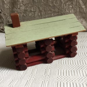 Antique Log Cabin Glued Together Using old Lincoln Logs Painted Red. Note Attached to the Cabin Dated 1884 Written with a Dip Pen in Red.