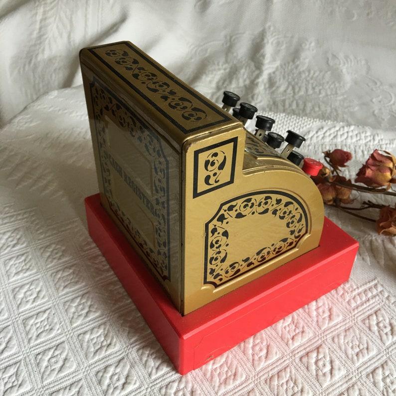 Gold With Black Print and Designs With Red Bottom Vintage Toy Cash Register Black and Red Plastic Handle Push Buttons to Raise Numbers.