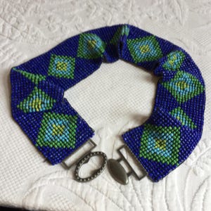 Vintage Southwestern Style Dehnbarer Perlengürtel mit Rauten in Blau und Grün. Locking Oval Schnalle auf der Vorderseite. 6,5 cm breiter Stretch Gürtel.
