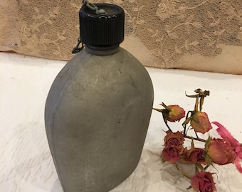 Vintage 1945 U.S., A.G.M.C.O. Cantina de botella de agua. Cantina de aluminio con tornillo de plástico en la parte superior con cadena. Cantina de botella de agua bien hecha.