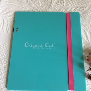 Tablero de escritura de escritorio de vuelta en azul aqua con correa elástica rosa para asegurar el material de escritura. Placa de escritorio de escritura nunca utilizada.