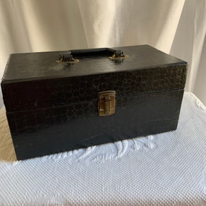 Vintage opbergdoos met hardboard handvat en vergrendeling met drie secties erin. Rode Fleur de Lis deksel met papieren voering. Rode voering aan de onderkant.