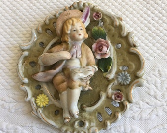 Vintage Porcelain Dimensional Plaque of Colonial Boy. Oval Wall Plaque from Occupied Japan. Molded Flowers and Boy with Book.