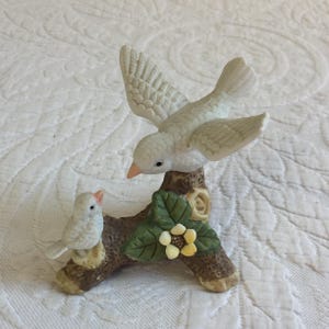 Vintage Bisque Porcelain Birds Figurine. Mama Bird Talking to Her Baby on a Branch with Green Leaves and a Yellow Flower.