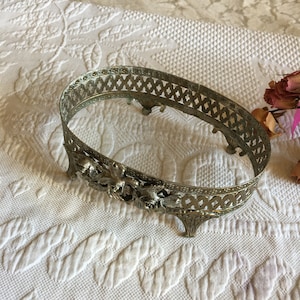 Vintage Dekorativer Halter. Ovale Kommode oder Schüsselhalter mit Rosen auf der Vorderseite und vier Beinen. Kleine biegbare Halter am unteren Rand.