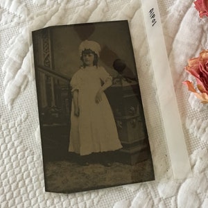 Victorian Tintype of Victorian Girl In White Dress/Nightgown and Ruffled Cap. She is Standing by a Stair Rail. Tinted Cheeks.