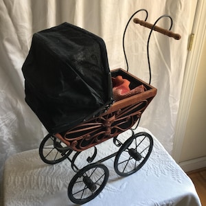 Vintage Wood, Wicker, Fabric and Metal Frame Doll Carriage. Wicker Butterfly Design, Fabric Raise and Lower Hood, Metal Wheels and Frame.