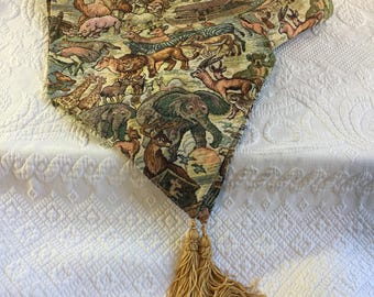 Caminho de mesa vintage em tapeçaria tecida com a Arca de Noé e pares de animais selvagens. Borlas douradas nas extremidades. 88,3 cm x 31,4 cm, borlas de 11,1 cm.