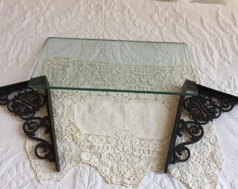 Vintage Wall Shelf with Cast Iron Gingerbread Bracket Holders. Black Openwork Fixtures and Clear Glass Shelf.