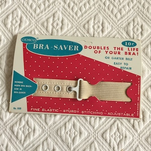 May include: A beige elastic bra saver with three metal eyelets and a white plastic buckle. The packaging reads "BRA-SAVER DOUBLES THE LIFE OF YOUR BRA!" and "GEMCO".