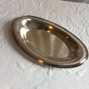 May include: A silver oval serving tray with a decorative, openwork border.