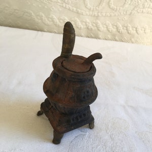 Poêle à ventre en fonte vintage avec plaque de poignée amovible sur le dessus. Revêtement antirouille léger.