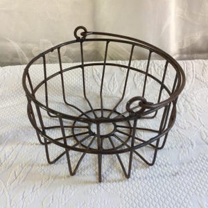 Cesta de metal marrón vintage para huevos con asa abatible. Ideal para decorar o para recoger huevos. Perfecta para jardinería o cualquier otra actividad.