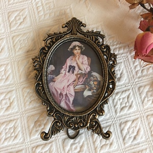 Victorian Fancy Cast Bronze Picture Frame. Oval Picture of a Lady in Pink with Cap. Wire Tabletop Stand and Wood Picture Back.