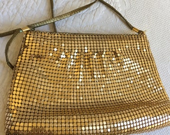 Monedero vintage de malla dorada con correa de hombro de vinilo dorado. Cierre de cremallera y bolsillo interior.