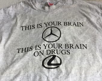 Vintage-Werbe-T-Shirt aus schwerer Hanes-Baumwolle, Größe L/G (42–44). Aufschrift: „This is Your Brain“ mit Mercedes- und Lexus-Emblemen.