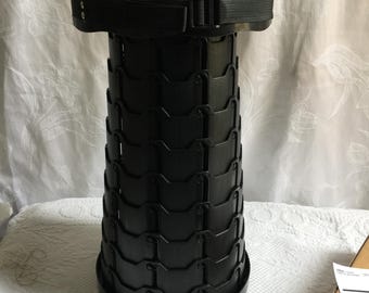 Taburete vintage Twist 'N Lock de plástico negro. Se expande y luego se pliega para guardarlo fácilmente.