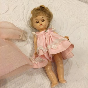 Vintage Blinking Eyes Small Doll with Blonde Hair and Green Eyes. Pink Pinafore Dress White Lace, Sheer Dotted Long Dress w/ Long Sleeves.