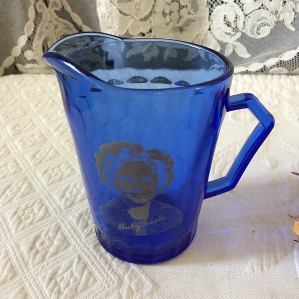 Vintage pichet de Shirley Temple avec sa photo sur un côté et un Design en nid d’abeille dans le verre de l’autre. Childs pichet bleu de Cobalt.