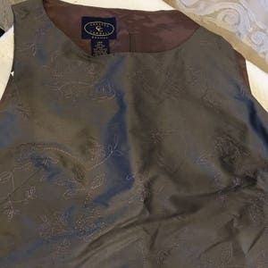May include: A brown sleeveless top with a floral embroidered design. The top has a label that reads "Chelsea Campbell Petite" and "14P".