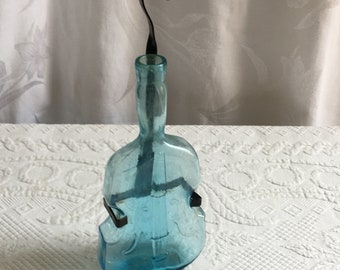 Vintage Light Blue Violin or Base Bottle with A Wrought Iron Belt and Hanger Loop. Very Old Bottle to Hang on the Wall to Display.