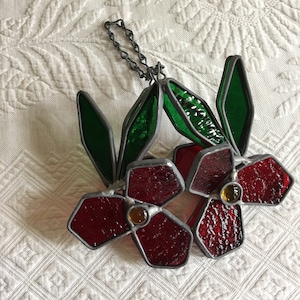 vintage Stained Glass Dimensional Hanging Decoration. Deux côtés identiques, fleurs rouges, centres jaunes et feuilles vertes sur la chaîne d’argent.