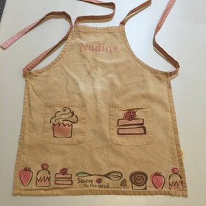 Mädchenschürze. Mary und Martha Koch- und Bastelschürze mit Namen Nadine, auf der Spitze. Krawatten für Hals und Taille. Zwei Taschen.