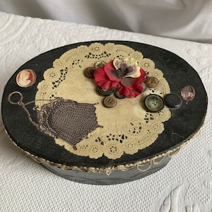 Caja ovalada de cartón pintado vintage con borde de encaje festoneado. Encaje de papel superior, botones reales de Pansey de seda, bolso de malla, camafeo. Gran costurero.