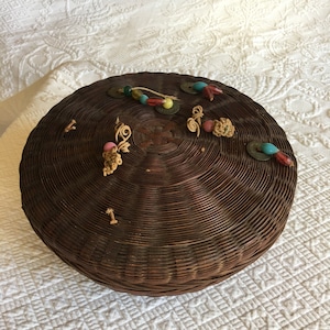 panier à coudre rond sur le thème chinois vintage. Le couvercle du panier a des perles, des pièces de monnaie chinoises et des fils pour décorer le dessus.