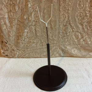 Vintage Metall Puppen Ständer für eine Puppe oder ein Flugzeug. Kunststoffbeschichteter gerader Metallhalter oben auf faux Holzbasis und Stange.