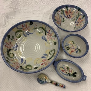Könnte beinhalten: Ein Set aus fünf handbemalten Keramikschalen mit einem Blumendesign in Blautönen, Gelb, Grün und Rosa. Die Schalen sind alle in verschiedenen Größen und Formen und eignen sich perfekt zum Servieren einer Vielzahl von Gerichten.