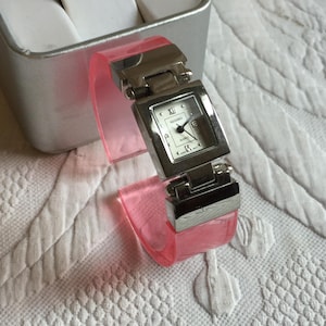 Vintage Kessaris Ladies Suare Face Quartz Watch. Accutime Watch Corp. Japan Movement and Stainless Back. Clear Pink Cuff Style Band.
