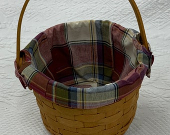 Cesta estilo Pascua Longaberger vintage de 1995 con forro de tela de algodón a cuadros. Manija oscilante y parte inferior central abovedada hacia adentro.