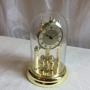 Seth Thomas AGO-170 Gold Tone Metal Base with Rotating Pendulum and Accurate Quartz Movement. Takes 2 AA Batteries not Included.