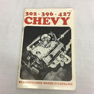 May include: Vintage "CHEVY" performance guide and catalog. The cover features the text "302 • 396 • 427 CHEVY" in red, with a black and white image of an engine. The text "PERFORMANCE GUIDE & CATALOG" is printed at the bottom.