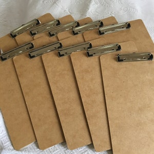 10 tableros de escritura en color natural de masonita con abrazadera de papel en la parte superior. Ideal para reuniones de grupo.