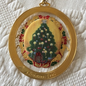 Vintage Avon 1995 Weihnachtsschmuck. Gold oval mit ChristbaumMedaillon auf goldfarbenem, rot und grün geprägtem Rücken. Sammler ornament.